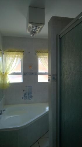 a bathroom with a bath tub and a window at Sea Otters Lodge in Kini Bay