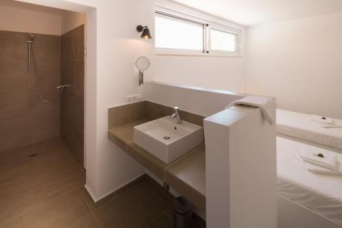 a white bathroom with a sink and a shower at Villa Koumaria in Sivota