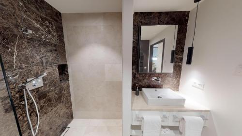 a bathroom with a sink and a shower at White Pearl Apartment 0.09 in Timmendorfer Strand