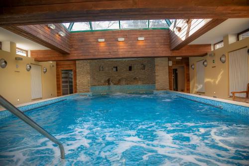 einem großen Pool in einem Gebäude mit einer Decke in der Unterkunft Hotel la Torre in Sauze dʼOulx