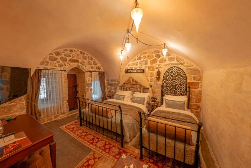 - une chambre avec 2 lits dans une pièce en pierre dans l'établissement Mardius Tarihi Konak, à Mardin