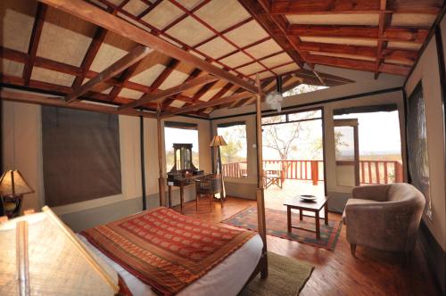 a bedroom with a bed and a living room at Elephant Rock Luxury Camp Tarangire in Kaiti