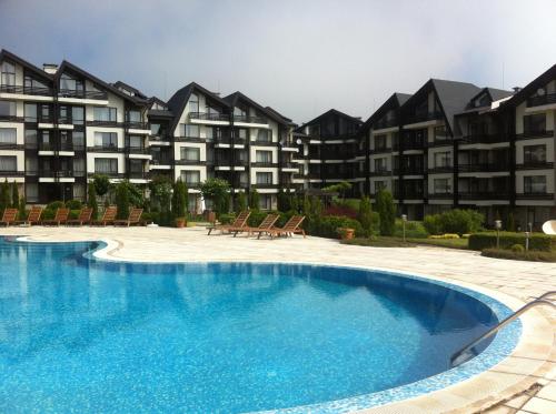 a swimming pool in front of some apartment buildings at ASPEN GOLF RESORT Ski & Spa RELAX APARTMENT in Bansko