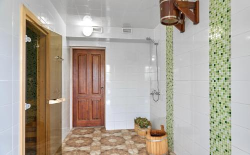 ロストフにあるHotel Rostovskyのバスルーム(シャワー付)、木製のドアが備わります。