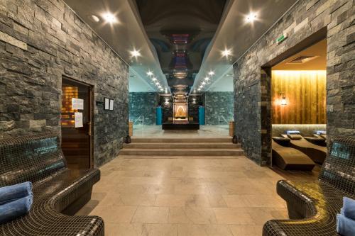 a lobby with couches and a staircase in a building at Sky Blue Hotel & Spa in Ploieşti