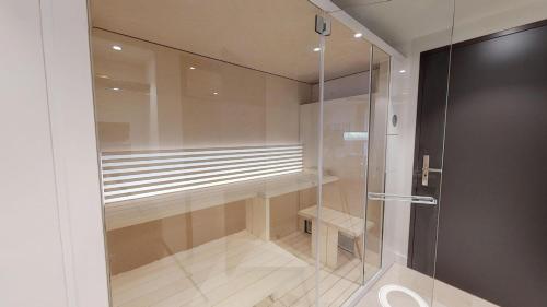 a walkin shower with a glass door in a bathroom at White Pearl Apartment 1.08 in Timmendorfer Strand