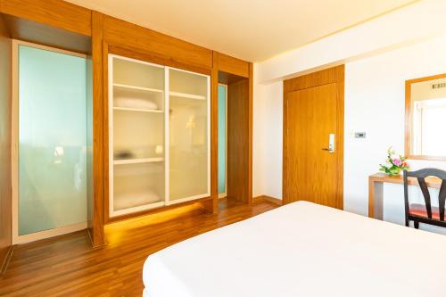 a bedroom with a bed and a sliding glass door at Viva Hotel Songkhla in Songkhla