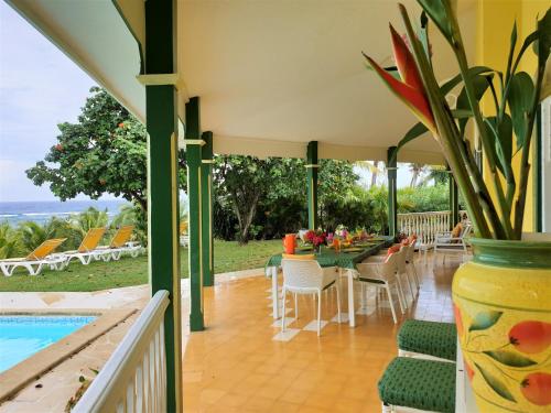 eine Terrasse mit einem Tisch, Stühlen und einem Pool in der Unterkunft Villa Guadeloupe Saint François Accès Mer Piscine IGUANA BAY - Villa Zagadi in Saint-François