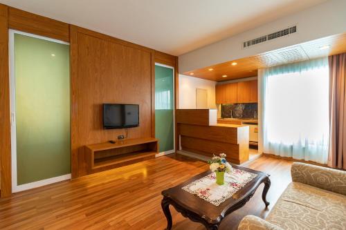 a living room with a couch and a tv at Viva Hotel Songkhla in Songkhla