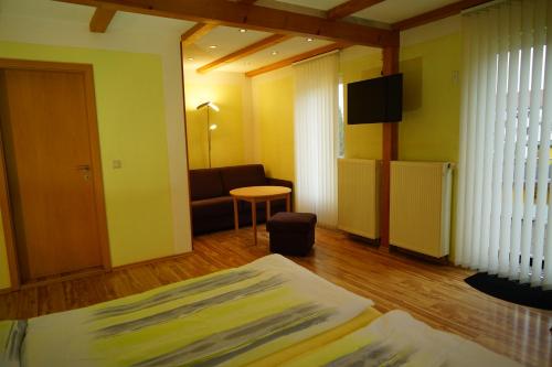 a room with a bed and a couch and a television at Pension Nr. 13 - B&B in Pirna