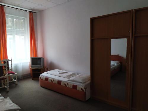 a bedroom with a bed and a cabinet with a mirror at Tourist room Maria in Ostrava