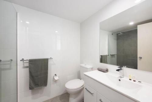 biała łazienka z toaletą i umywalką w obiekcie Winning Post Motor Inn w mieście Mudgee