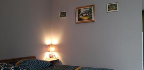 a bedroom with a bed and a picture on the wall at La ferme du Grand Faubourg in Pont-de-Vaux
