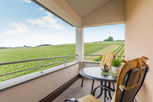a balcony with a table and chairs and a view of a field at Ferienhof Berger UG in Hagnau