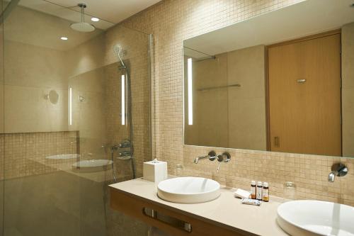 baño con 2 lavabos y espejo grande en Sunrise Jade - Adults Only en Protaras