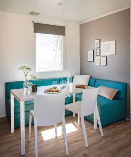 a dining room with a white table and chairs at PetraLegna in Porto-Vecchio