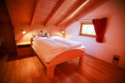 ein Schlafzimmer mit einem Bett in einem Zimmer mit einem Fenster in der Unterkunft Agritur Dal Fior La Casa nel Bosco in Rundscheinberg