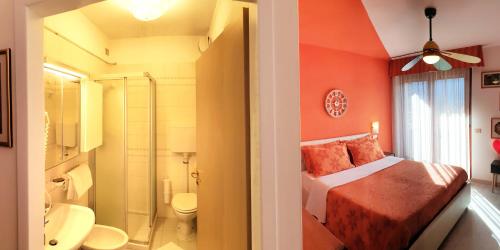 a bathroom with a bedroom with a bed and a shower at Family Hotel Primavera in Levico Terme