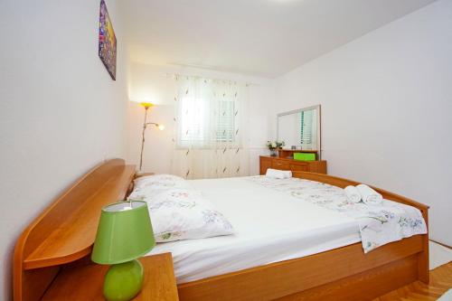 ein Schlafzimmer mit einem großen Bett und einer grünen Lampe in der Unterkunft Apartment Danica in Makarska