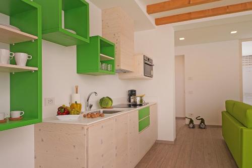 a kitchen with green and white cabinets and a sink at Agriturismo Hegemone in Tremosine Sul Garda