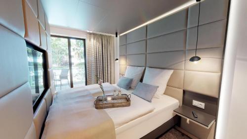 ein Schlafzimmer mit einem weißen Bett und einem Korb darauf in der Unterkunft White Pearl Apartment 1.09 in Timmendorfer Strand
