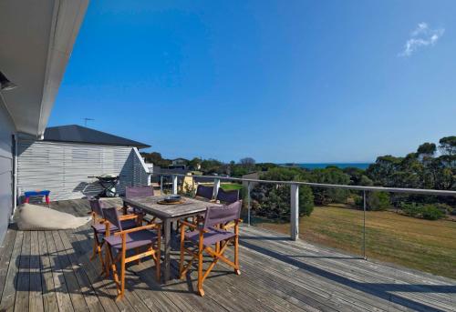 a wooden deck with a table and chairs on it at Waders in Coles Bay