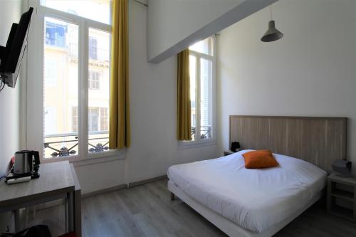 馬賽的住宿－艾斯特勒公寓式酒店，卧室配有白色的床和2扇窗户。