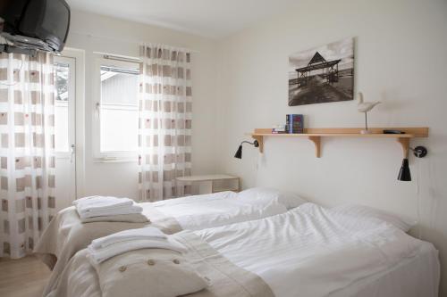 1 dormitorio con 2 camas blancas y ventana en Åhus Resort, en Åhus