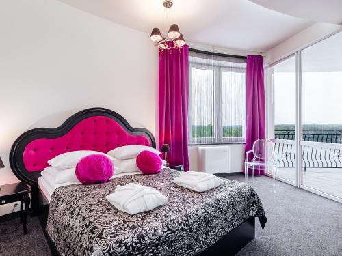 a bedroom with a large bed with pink pillows at Hotel Woiński Spa in Lubniewice