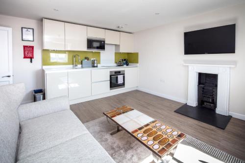 a living room with a couch and a fireplace at Charlotte Rise - Urban Apartments in Bristol