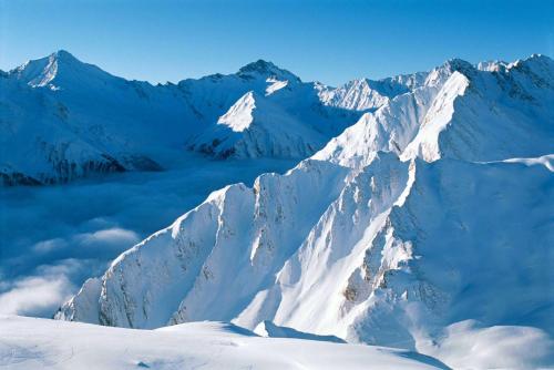 a mountain covered in snow with clouds in front of it at Patschei Trid in Samnaun