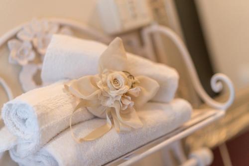 a pile of towels and a flower on a shelf at B&B Il Biancospino in Abbadia San Salvatore