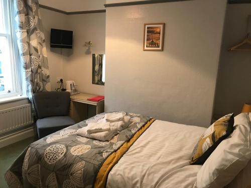 a bedroom with a bed and a desk and a chair at Winchester House in Keswick