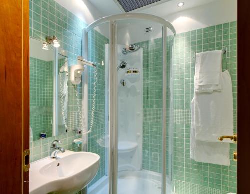 ローマにあるホテル コロトの緑のタイル張りのバスルーム(シンク、シャワー付)