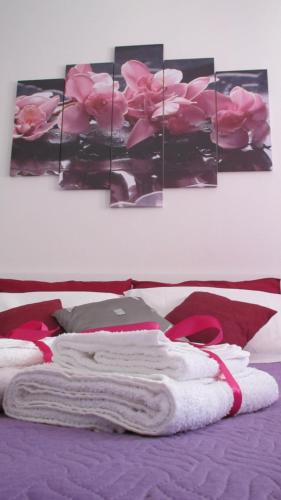 バレストラーテにあるAppartamento MANILAのピンクのバラの絵が飾られたベッド