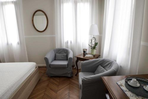 a bedroom with a bed and two chairs and a table at Prosecco Collalto Lodge in Susegana