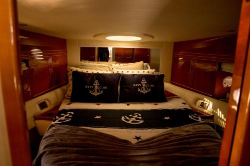 a small room with a bed with black and white pillows at AQUADOURO Yacht RADAMES - Sleep Boat Experience in Castelo de Paiva