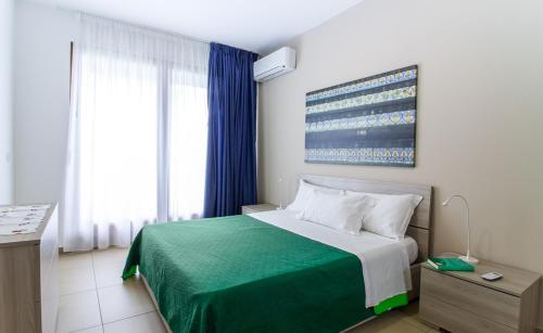 a bedroom with a large bed with a green blanket at Residence Rapisardi by RECEPTIO in Catania