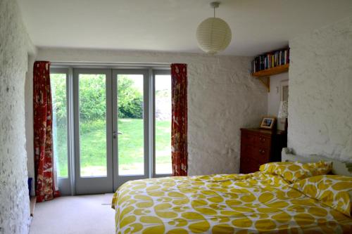 - une chambre avec un lit et une porte coulissante en verre dans l'établissement Potato, Barafundle Barns, SA71 5LS, à Pembroke