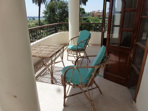 a balcony with chairs and a table and a table at DREAM ISLAND Hotel in Luxor