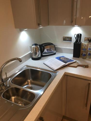 a kitchen counter with a sink and a tea kettle at Portfolio Apartments - Welwyn Business Park in Welwyn Garden City
