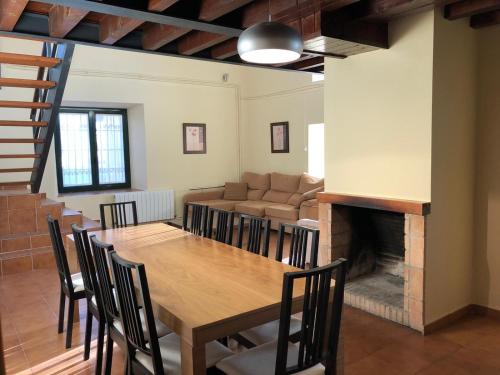 ein Esszimmer mit einem Tisch und einem Sofa in der Unterkunft Casa Rural Fuente la Bolera in Gilbuena