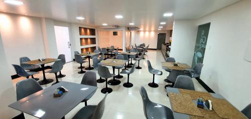 a room with tables and chairs in a restaurant at Hotel Gemeos in São Mateus