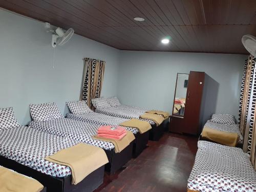 a row of beds in a room with a mirror at Edgestay in Mudigere