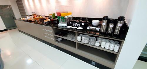 a kitchen counter with a bunch of food on it at Hotel Gemeos in São Mateus