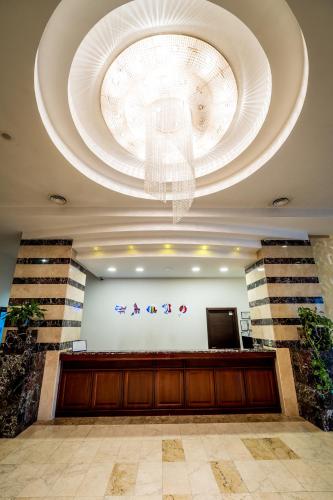 a lobby with a large chandelier in a building at Grand Hotel in Târgu-Mureş