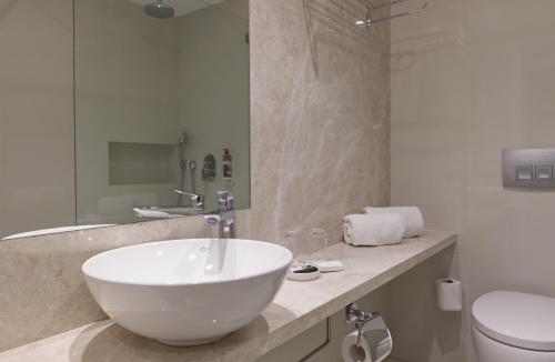 a bathroom with a white sink and a toilet at Sunrise Gardens Aparthotel in Protaras
