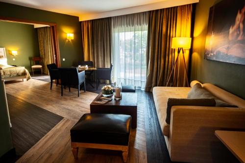 a living room with a couch and a table in a hotel room at Dion Palace Resort and Spa in Limani Litochorou
