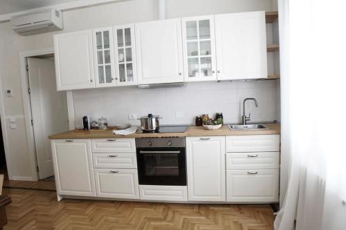 a white kitchen with white cabinets and a sink at Prosecco Collalto Lodge in Susegana