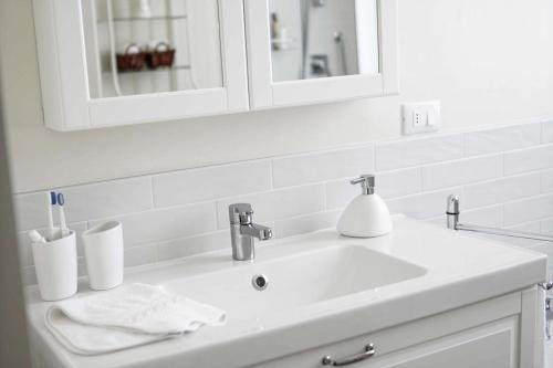 a white bathroom sink with a mirror and toothbrush at Prosecco Collalto Lodge in Susegana